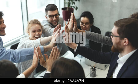 Motivated business team giving group high five Stock Photo