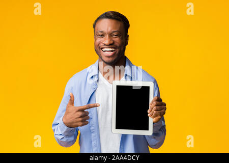 Man Pointing Finger At Tablet Screen Standing, Studio Shot, Mockup Stock Photo