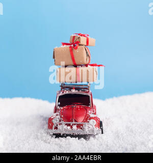 Retro car Volkswagen Beetle with Christmas presents over blue background Stock Photo