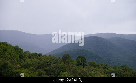 Southern highlands. Field with low mountains. Low mountains with trees. Anapsky district, Russia. Journey. Summer mountain landscape Stock Photo