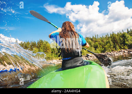 Young woman on kayak with spray paddle. Concept travel summer day. Stock Photo