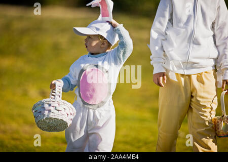 Two brothers in Easter costumes on an Easter egg hunt Stock Photo