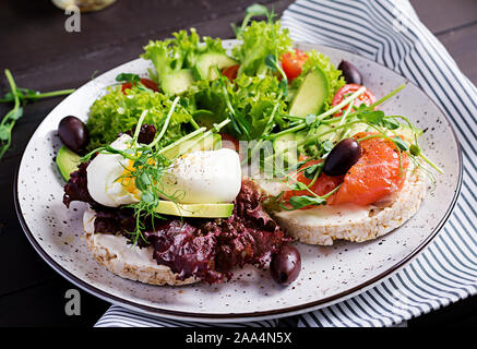 Healthy breakfast. Sandwiches with cream cheese, boiled egg and smoked salmon, avocado on plate. Stock Photo
