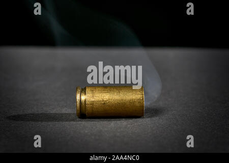 smoking bullet casing fired out of a handgun dropped on the ground Stock  Photo - Alamy