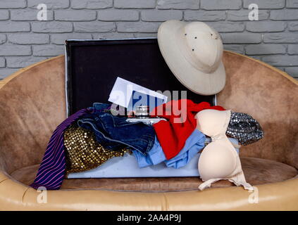 old suitcase full of men's and women different things for the rest ready for travel Stock Photo