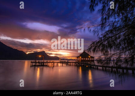 Silhouette of a Wooden pier on Ora Beach at sunset, Seram, Maluku Islands, Indonesia Stock Photo