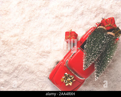 Red Christmas truck with Christmas trees and gift boxes in the snow, view from above, space for your text on the left side Stock Photo