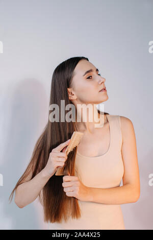 Woman combing her long hair Stock Photo