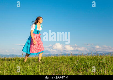 Eine hübsche junge Frau, die ein klassisches bayerisches Trachtengewand traegt Stock Photo