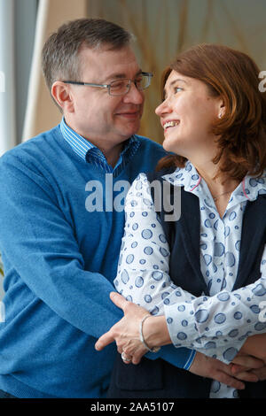 Husband hugs his wife. Husband and wife look at each other and smile Stock Photo