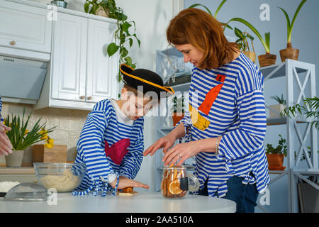 Photo session - friendly family. The family cooks together. Mom and son knead the dough with flour. Prepare the dough in the kitchen. Stock Photo