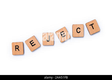 The word REJECT, spelt with wooden letter tiles over a white background. Stock Photo