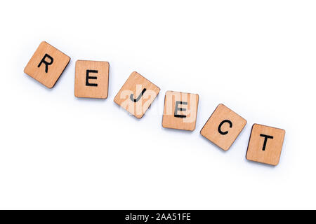 The word REJECT, spelt with wooden letter tiles over a white background. Stock Photo