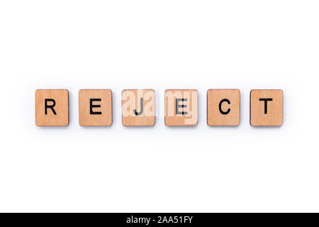 The word REJECT, spelt with wooden letter tiles over a white background. Stock Photo