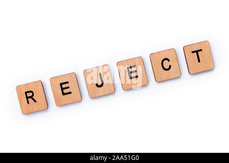 The word REJECT, spelt with wooden letter tiles over a white background. Stock Photo