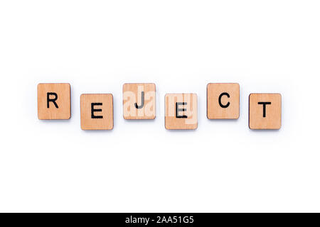 The word REJECT, spelt with wooden letter tiles over a white background. Stock Photo