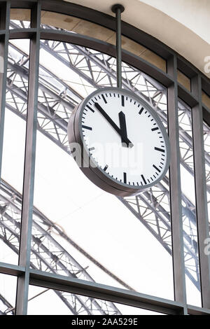 Alone train station's clock hangs on big window Stock Photo