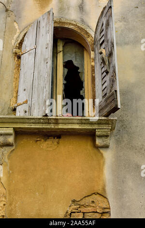 Old, derelict window with broken wooden shutters and glass in old building Croatia Stock Photo