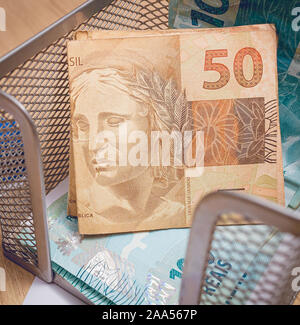 Real - Brazilian Currency. Money bills in a paper holder. Stock Photo