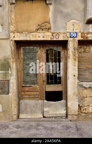 Old, derelict wooden door with broken windows in old building Croatia Stock Photo