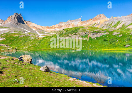 Landscape open view of green grass meadow field and Ice lake water reflection near Silverton, Colorado in August 2019 summer on summit Stock Photo