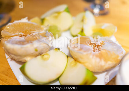 Sour foods sliced fruit serving setting on wooden table white plate closeup for miracle berry tasting or breakfast with grapfruit and apple slices Stock Photo