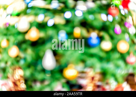 Christmas xmas bokeh abstract background with red, blue and green ornaments decorations on festive tree bright lights Stock Photo