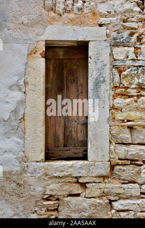 Old boarded up window in stone wall Stock Photo