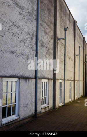 Angled side view of commercial building showing multi paned windows and down pipes Stock Photo