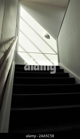 A sunlit staircase in an older style office  building Stock Photo