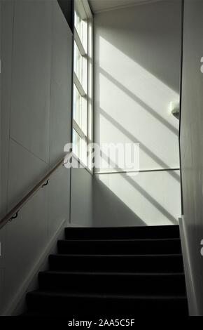 A sunlit staircase in an older style office  building Stock Photo