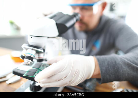 Man soldering using microscope Stock Photo