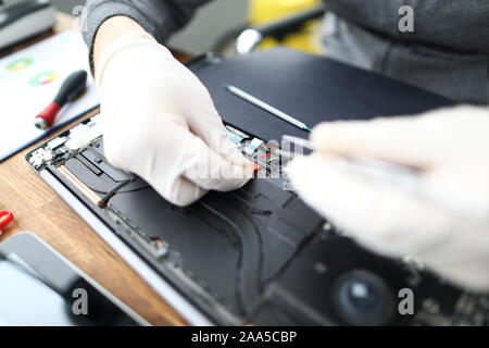 Laptop repair technician with tool Stock Photo