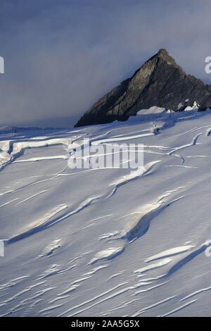 Aerial photo of a rocky spire and a crevasse filed glacial snowfield in the Chugach Mountains, Alaska Stock Photo