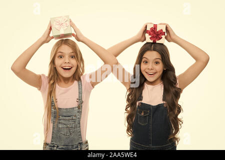 Learned how to gift wrap. Happy little girls holding gift boxes over head. Small children with gift packs on boxing day. Adorable kids with beautifully wrapped birthday gift boxes. Stock Photo