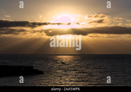 Game of light and shadow generated by the sunrise and clouds covering the sky over the sea Stock Photo