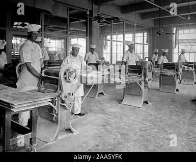 Industries of War - Chewing Gum - MANUFACTURING CHEWING GUM. Running gum through press in plant of Beech-Nut Packing Co., Canajoharie, New York ca. 1918 Stock Photo