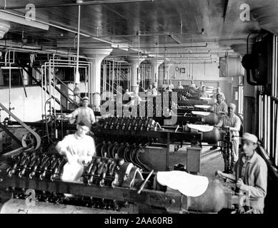 Industries of War - Chewing Gum - WRIGLEY FACTORY Extracting all foreign matter from chicle by forcing it through heavy fine-mesh canvas cloths ca. 1918 Stock Photo