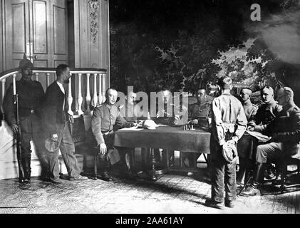 In the hands of the Germans. This remarkable picture, the first ever published of a German military court in France, shows a French peasants on trial for having been found with a rifle. Beside the sentry stands a witness. The court room is a French chateau. Note the tapestry behind the German officers. ca. 1918 Stock Photo