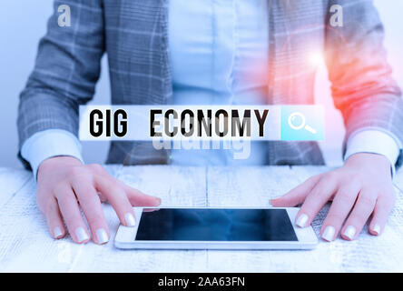 Handwriting text Gig Economy. Conceptual photo free market system in which temporary positions are common Business woman sitting with mobile phone on Stock Photo