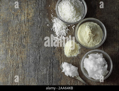 natural and organic coconut oil, coconut flour, coconut shreds ingredients in glass bowls Stock Photo