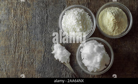 natural and organic coconut oil, coconut flour, coconut shreds ingredients in glass bowls Stock Photo