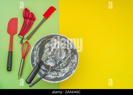 Baking utensils accessories, and mixer bowl on flat lay, green yellow background Stock Photo