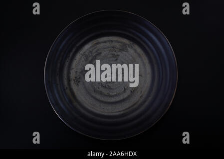 a dark grey ceramic plate with a water ripple Stock Photo