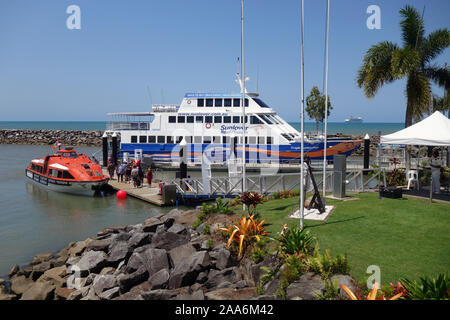 Passengers from cruise ship Pacific Dawn (visible on horizon) transferring to local reef tour boat, Yorkey’s Knob marina, Cairns, Queensland, Australi Stock Photo