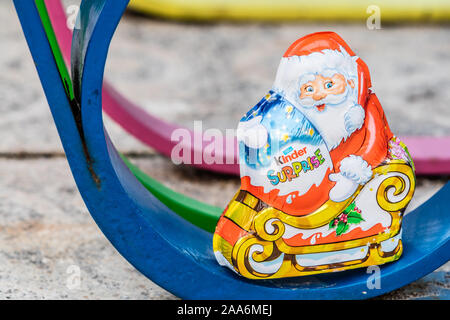 Kinder Surprise Santa Claus Christmas egg consists of a chocolate shell, a plastic capsule with toy, and external foil wrap. Made by Ferrero Co. Stock Photo