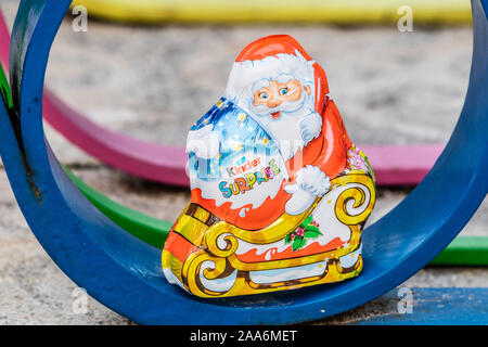 Kinder Surprise Santa Claus Christmas egg consists of a chocolate shell, a plastic capsule with toy, and external foil wrap. Made by Ferrero Co. Stock Photo