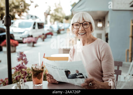 Joyful happy woman reading a morning newspaper Stock Photo