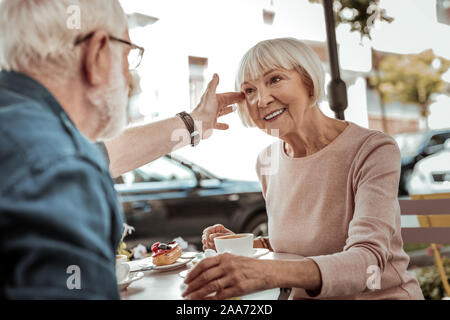 Nice aged man touching his wifes hair Stock Photo