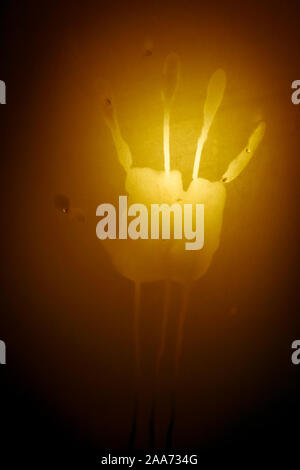 Psycho creepy shadowy palm handprint on bathroom shower frosted transparent door Stock Photo